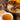Tea cup with dried chaga mushroom, cinnamon sticks, and flowers on a wooden surface
