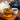 Tea cup with tea, teapot, and bowl of china green tea leaves on a wooden surface