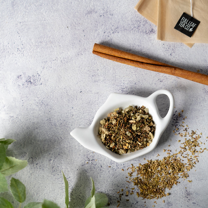 White dish with congestion relief tea, cinnamon sticks, and a Full Leaf Tea Co. bag on a gray surface.