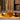 Glass mug of tea on a wooden tray with books in the background