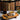 Tea cup with saucer on a wooden tray in front of a bookshelf