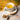 Tea cup with floral design, wooden spoon, and valerian root on a wooden surface.