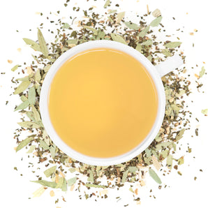 A white cup of Organic Constipation Relief tea surrounded by the loose leaf blend.