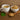 White cup of tea with a bowl of dried herbs on a wooden surface