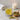 Glass of senna leaf tea with a bowl of tea leaves and a candle in the background