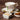 Teacup with floral design on a wooden table, accompanied by a small bowl of slippery elm and a bowl of honey.