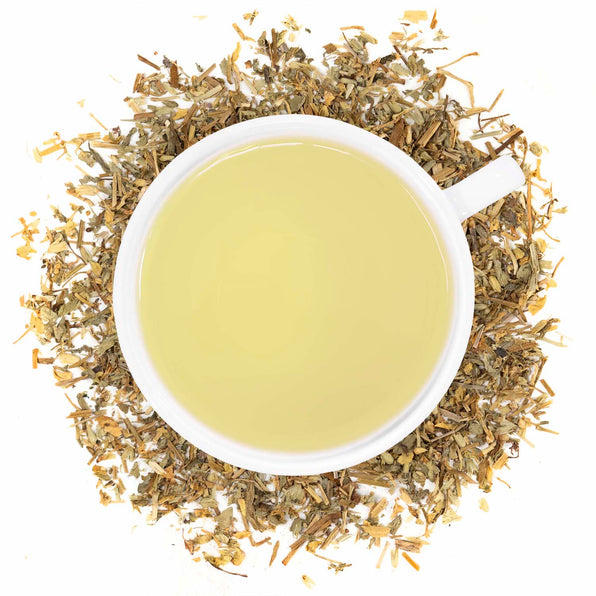 A cup of Organic Chickweed tea with dried chickweed leaves scattered around.