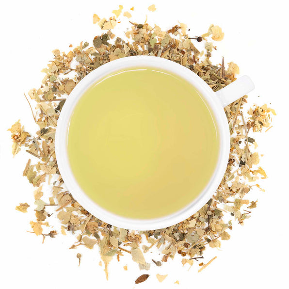 A cup of brewed Organic Linden Leaf tea with visible dried Linden leaves around it.