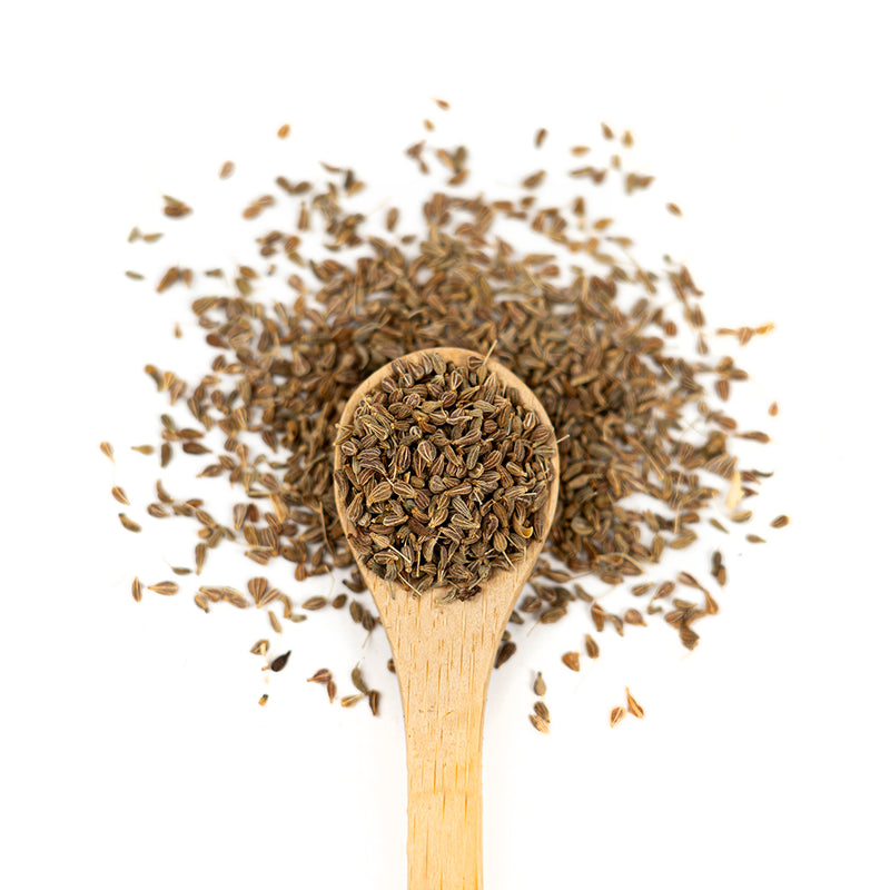 Wooden spoon of Organic Anise Seeds on a white background.