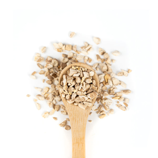 Wooden spoon of Ashwagandha Root on a white background.