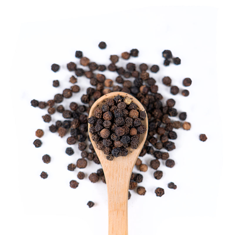 Wooden spoon of Organic Black Pepper on a white background.