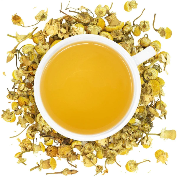 A white cup with Organic Chamomile Tea surrounded by the ingredient.