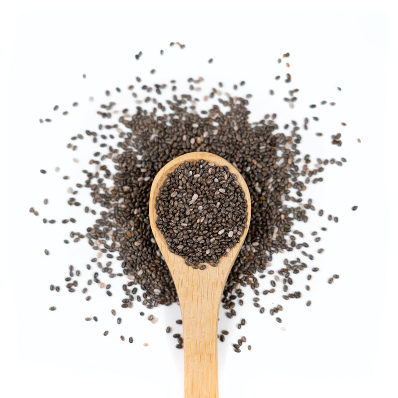 Wooden spoon of Organic Chia Seeds on a white background.