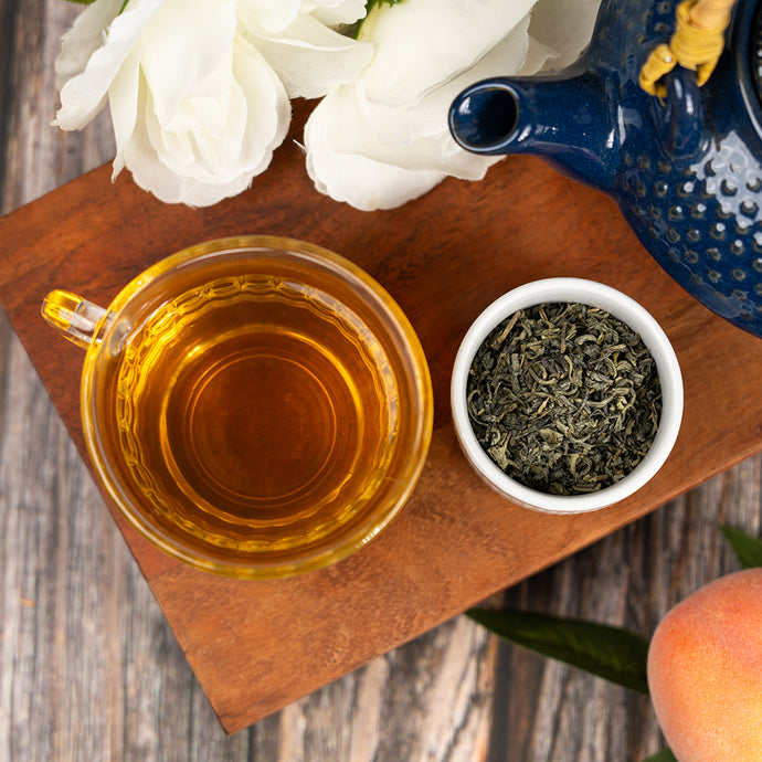 Tea cup with china green tea leaves and flowers on a wooden board