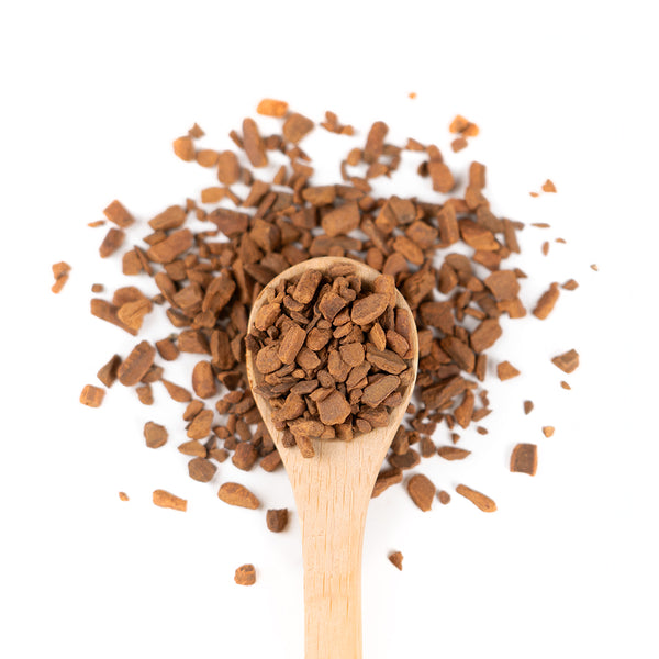 Wooden spoon of Organic Cinnamon on a white background.