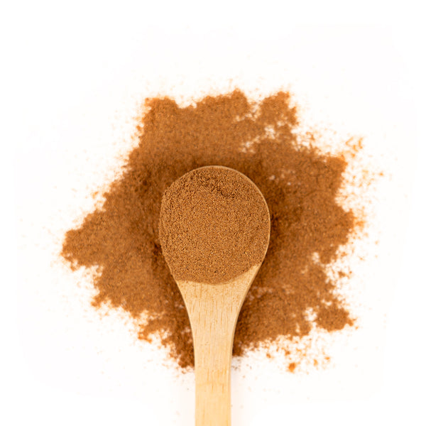 Wooden spoon of Organic Cinnamon on a white background.