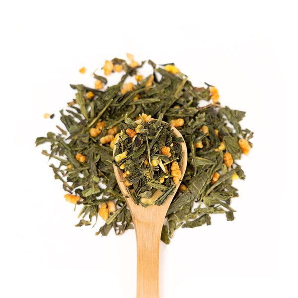 Wooden spoon of Organic Genmaicha on a white background.