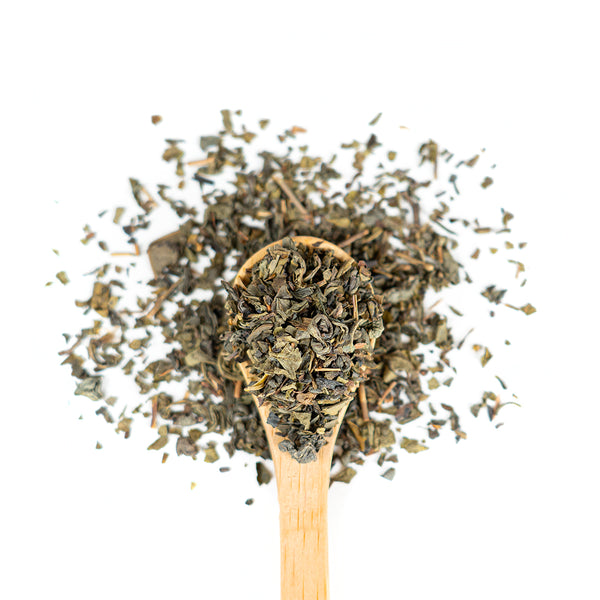 Wooden spoon of Organic Gunpowder Green on a white background.