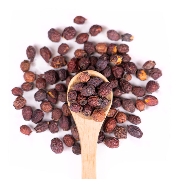 Wooden spoon of Organic Hawthorn Berries on a white background.