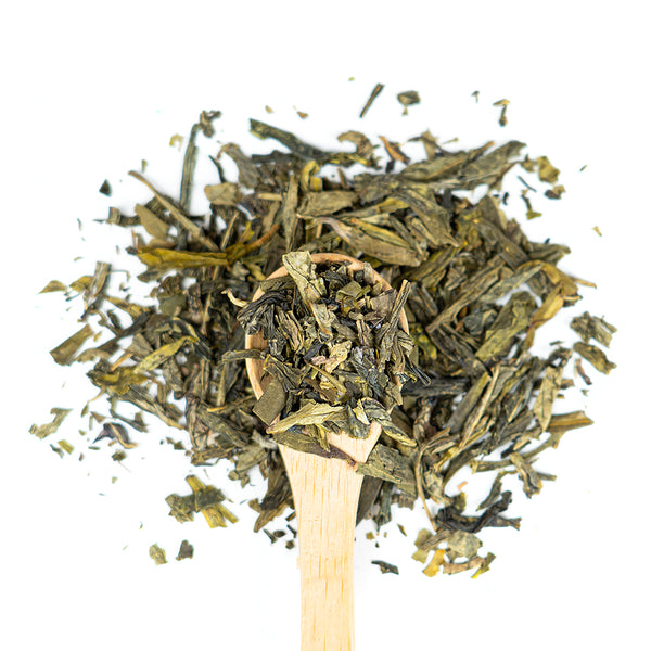 Wooden spoon of Organic Lung Ching on a white background.
