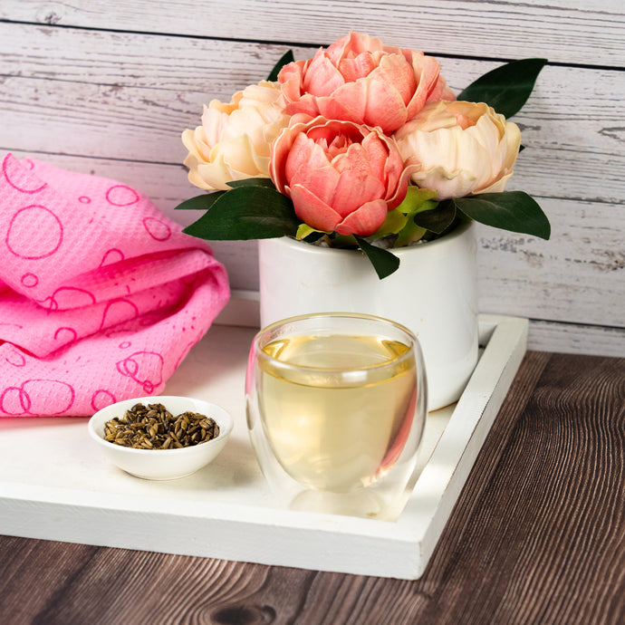 Tea cup with flowers and milk thistle leaves on a wooden surface