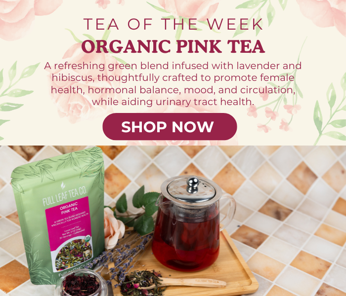 Promotional image of organic pink tea with packaging and a teapot on a wooden board.