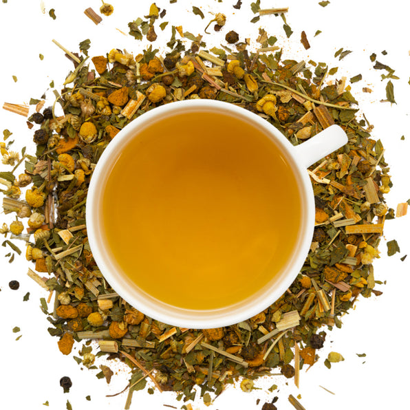 White cup of muscle cramp tea surrounded by dry muscle cramp tea herbs on a white background