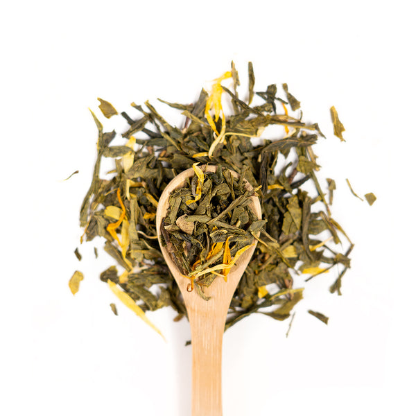 Wooden spoon of Organic Peach Green loose leaf tea on a white background.