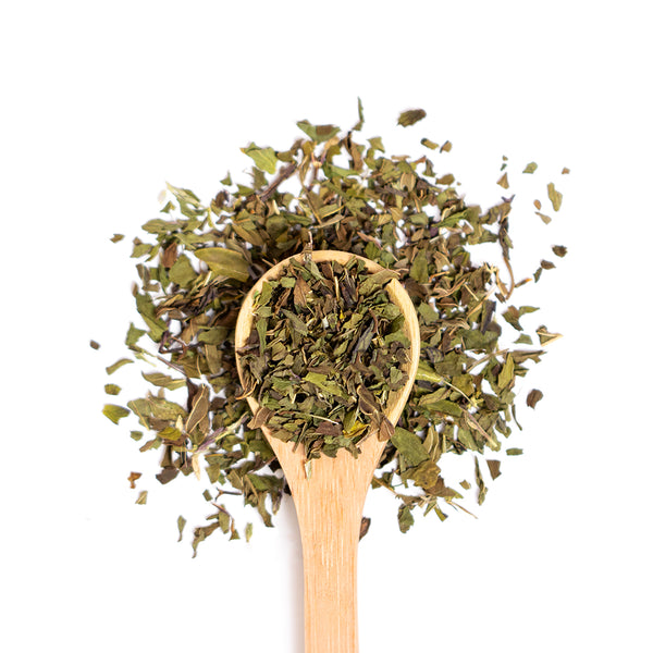 Wooden spoon of Organic Peppermint on a white background.