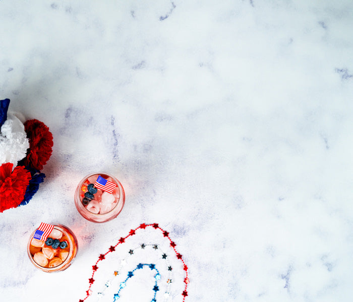Two small cups with red, white, and blue decorations on a white marble surface.