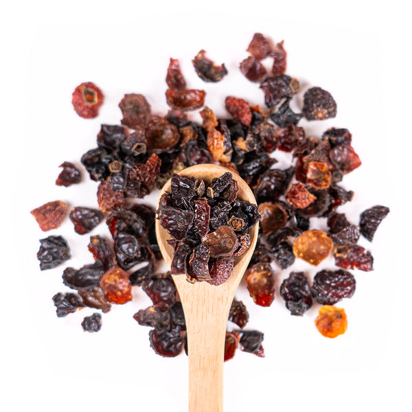 Wooden spoon of Organic Rosehips on a white background.
