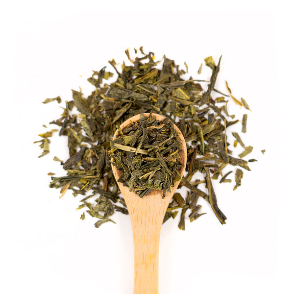 Wooden spoon of Organic Sencha on a white background.