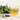 Glass cup of spearmint tea with light golden color on a white surface beside a small bowl of dried spearmint leaves and a bunch of fresh green spearmint leaves in the background.
