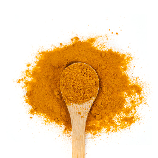 Wooden spoon of Organic Turmeric on a white background.