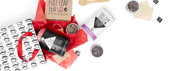 Various Full Leaf Tea Co products on a white surface with a gift bag. 