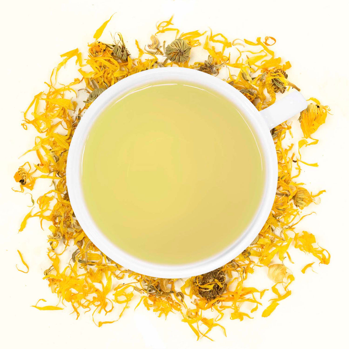 A white mug filled with calendula tea surrounded by calendula
