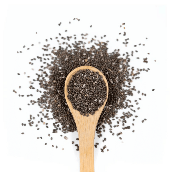 A wooden spoon filled with and surrounded by chia seeds on a white background. 