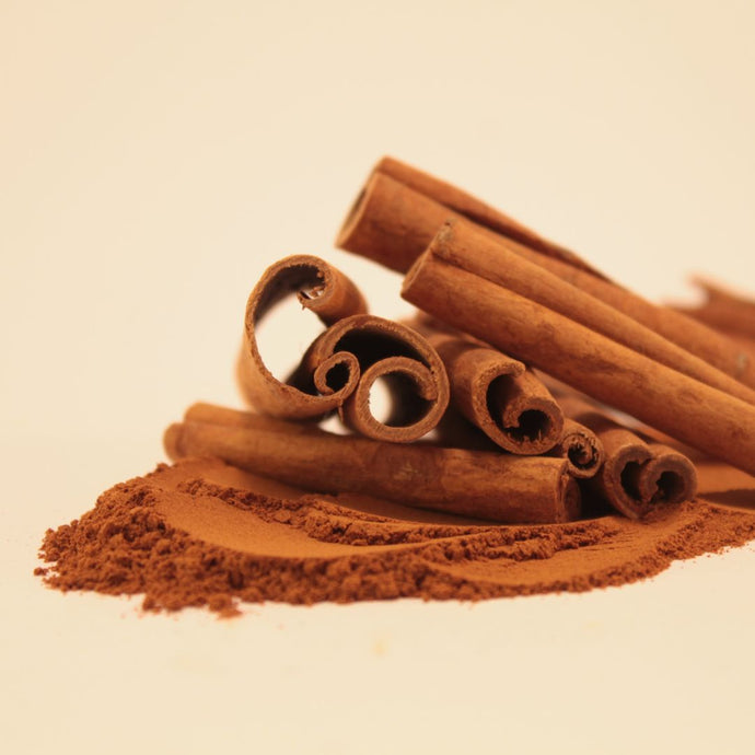 Cinnamon sticks and ground cinnamon on a beige background