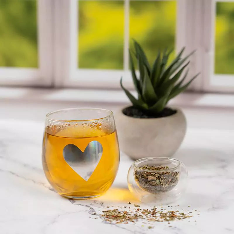 Glass of tea sitting on marble counter, next to dish of ingredients