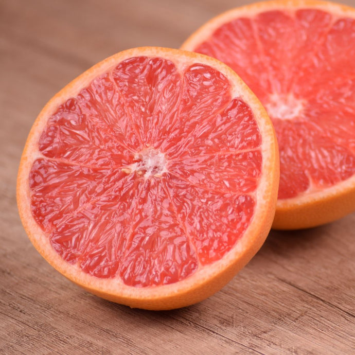 Close-up of a halved grapefruit on a wooden surface