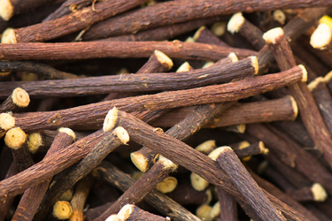 Close-up of dried licorice root sticks showing their rough brown texture and cut ends.